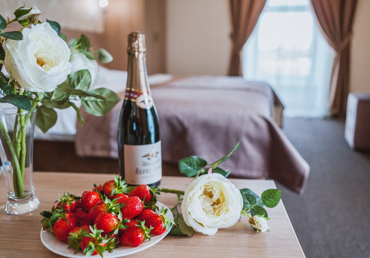 Клубника и цветы на столике в номере Делюкс
